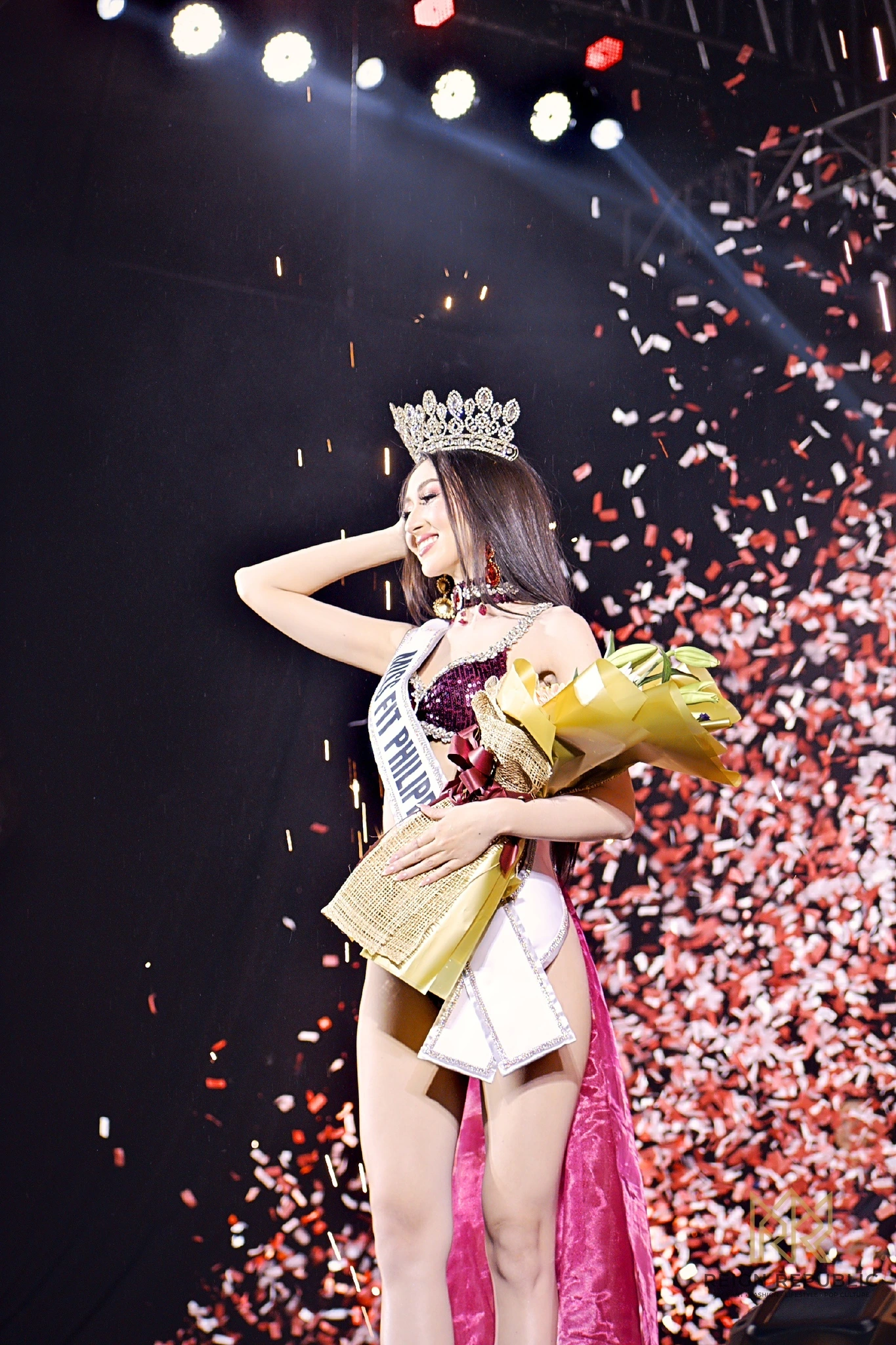Kailey Rose Kemp, crowned and holding her bouquet, under a shower of confetti.